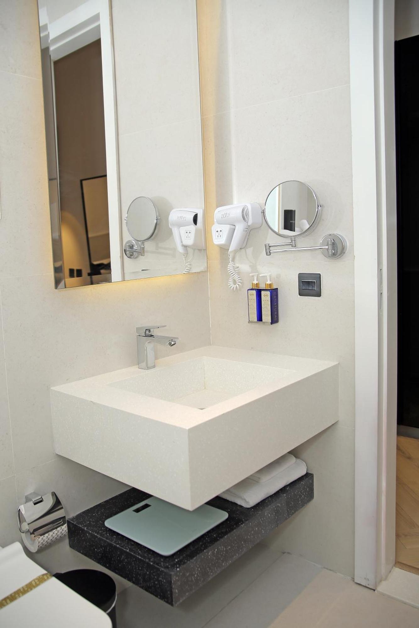 Ambiance Boutique Art Hotel Lahore Quarto foto A wall mounted hair dryer in a hotel bathroom